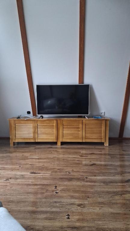 Zona media cu TV cu ecran plat și comodă din lemn